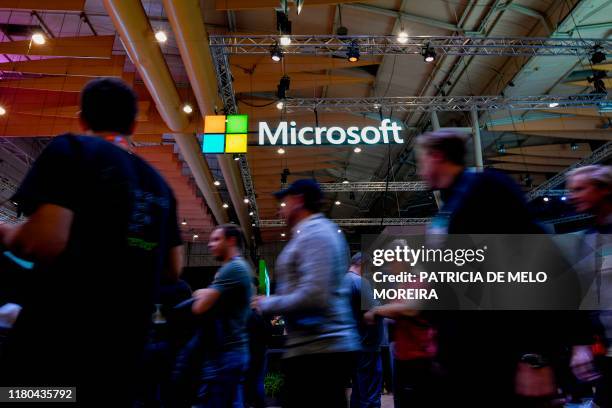 Attendees walk past the logo of US multinational technology company Microsoft during the Web Summit in Lisbon on November 6, 2019. - Europe's largest...