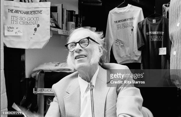 View of American science fiction & mystery writer Isaac Asimov as he sits in a booth during the 'New York is Book County' fair, New York, New York,...