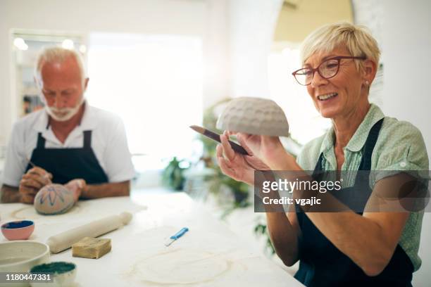 senior couple at ceramics workshop - painting pottery stock pictures, royalty-free photos & images