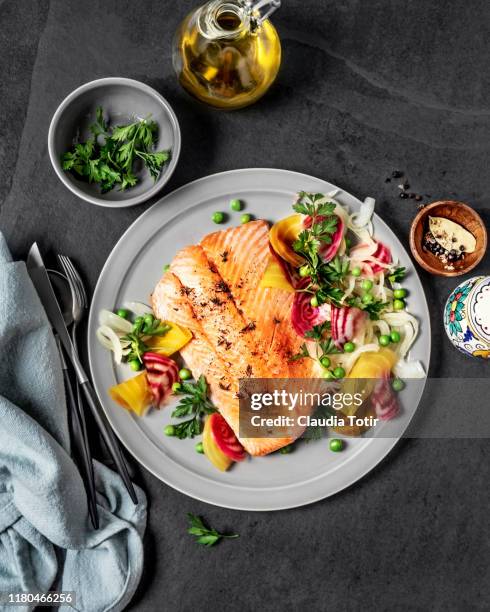 pan fried salmon with vegetables on black background - aliment préparé en filet photos et images de collection