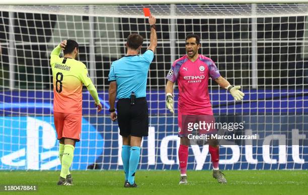 Referee Alaksei Kulbakov shows the red card to Claudio Bravo of Manchester City during the UEFA Champions League group C match between Atalanta and...