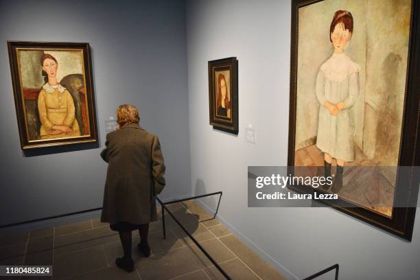 Visitor looks at the paintings 'Fillet en robe jaune', 'Fillet en blue' and 'Jeune fille rousse' by Italian artist Amedeo Modigliani before the...