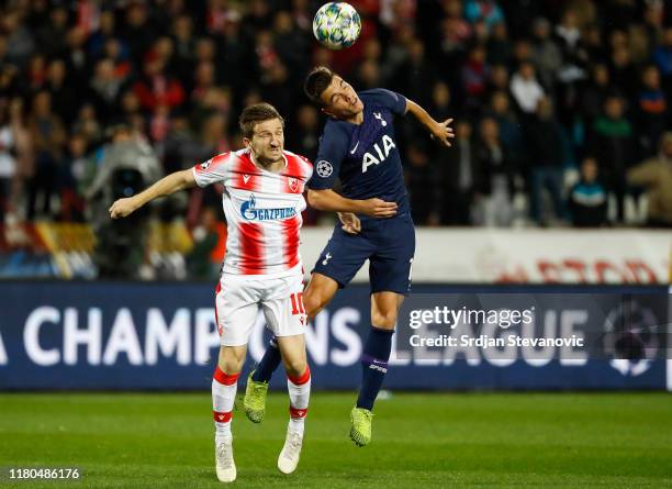 Giovani Lo Celso of Tottenham Hotspur jumps for the ball against Marko Marin of Crvena Zvezda during the UEFA Champions League group B match between...