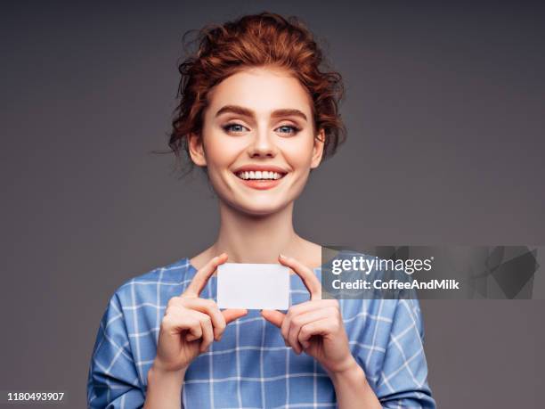 young woman holding a business card - showing card stock pictures, royalty-free photos & images