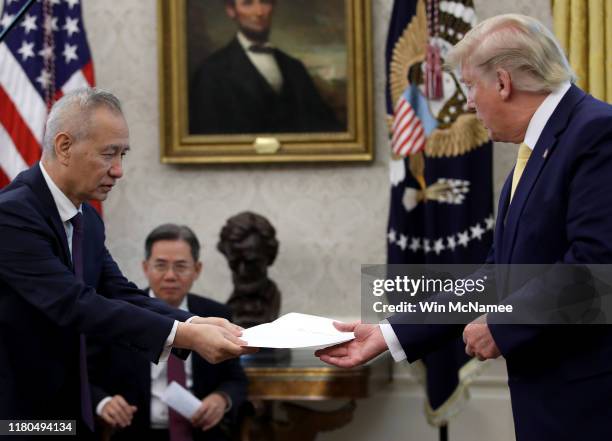 Chinese Vice Premier Liu He presents U.S. President Donald Trump with a letter from Chinese President Xi Jinping after Trump announced a "phase one"...