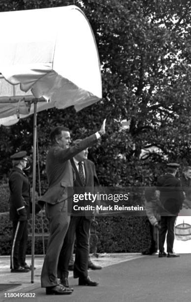 Vice President George HW Bush and Attorney General designate Edwin Meese stand at the South Portico canopy waiting to greet President Ronald Reagan...