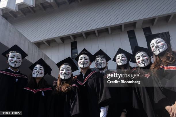 Graduates wearing anonymous masks, also known as Guy Fawkes masks, pose for a photograph following a graduation ceremony at the Chinese University of...
