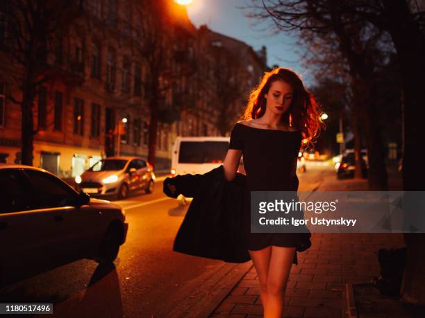 beautiful redhead woman in city street at night - femme robe blanche photos et images de collection