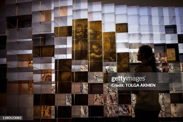 Gallery workers pose during a photocall for the upcoming 'Leonardo: Experience a Masterpiece' exhibition at the National Gallery in London on...