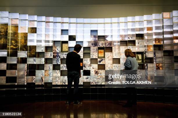 Gallery workers pose during a photocall for the upcoming 'Leonardo: Experience a Masterpiece' exhibition at the National Gallery in London on...