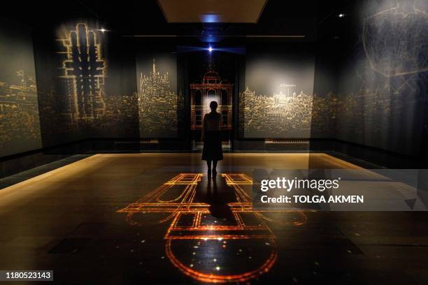 Gallery worker poses with a projection of an imagined chapel during a photocall for the upcoming 'Leonardo: Experience a Masterpiece' exhibition at...