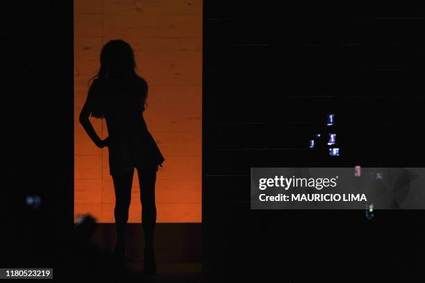 Snapshot cameras and mobiles appear in the dark while US socialite Paris Hilton starts the show by Triton during the 2010-2011 Spring-Summer...