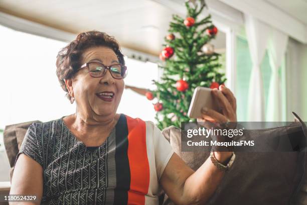 oma erhält weihnachtsbotschaft per smartphone - chrismas brasil stock-fotos und bilder