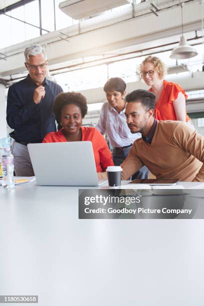 fokussierte gruppe unterschiedlicher geschäftsleute, die einen laptop bei der arbeit verwenden - employees diversity stock-fotos und bilder