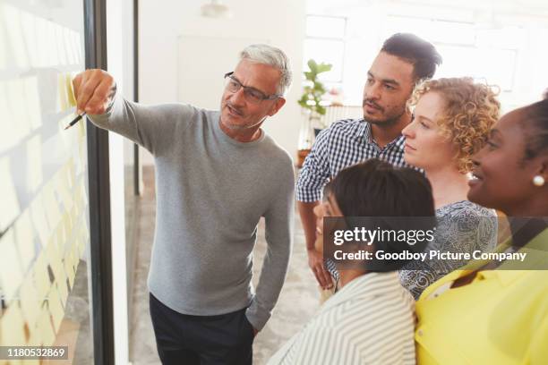 vielfältige geschäftsleute brainstorming mit klebenotizen in einem meeting - flowchart stock-fotos und bilder