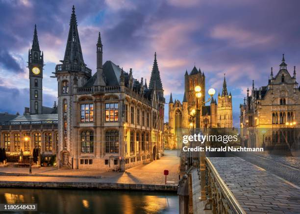 view of the historic area of graslei and bell tower at river leie and bridge sint-michielsplein at dusk, ghent, belgium - gand belgio foto e immagini stock
