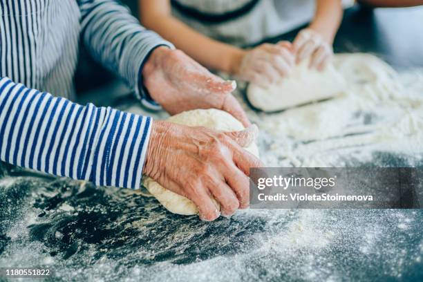 grandmother teaching her granddaughter to make cookies - baking bread imagens e fotografias de stock