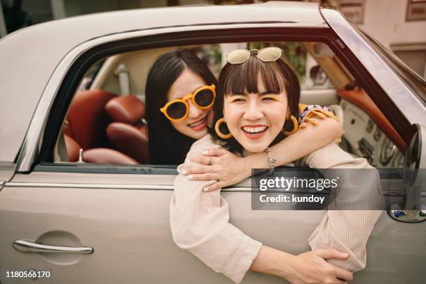 portrait of happiness young woman friends with car in road trip. best friends concept. - asian couple car stockfoto's en -beelden