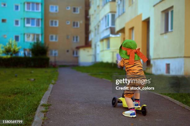 baby girl riding toy scooter - tiger girl stock pictures, royalty-free photos & images