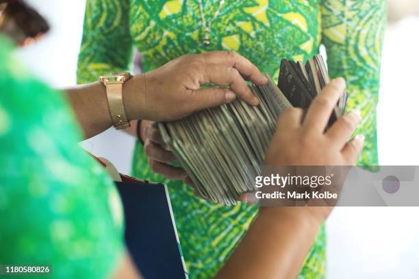 Cook Islands performers hold the traveling group's passports as they prepare to travel to Sydney at Rarotonga Airport on October 11, 2019 in...