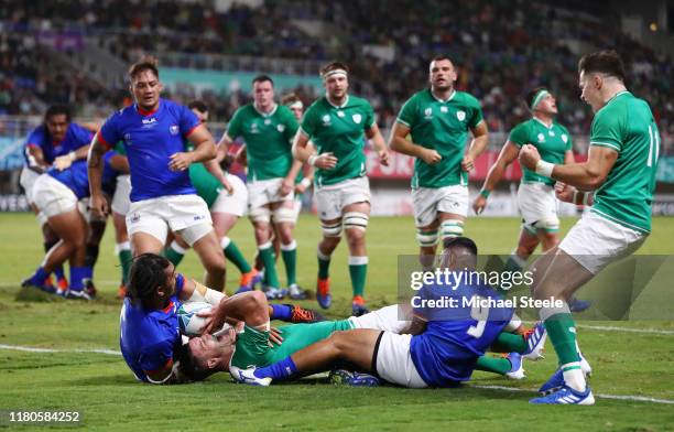 Johnny Sexton of Ireland scores his team's fourth try past Dwayne Polataivao and Chris Vui of Samoa during the Rugby World Cup 2019 Group A game...