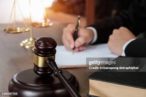 law, lawyer attorney and justice concept, male lawyer or notary working on a documents and report of the important case in the law firm,bangkok,thailand - tribunal stock pictures, royalty-free photos & images