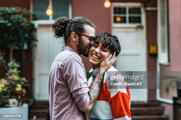 young couple embracing outside in the street - cat hipster no stock pictures, royalty-free photos & images