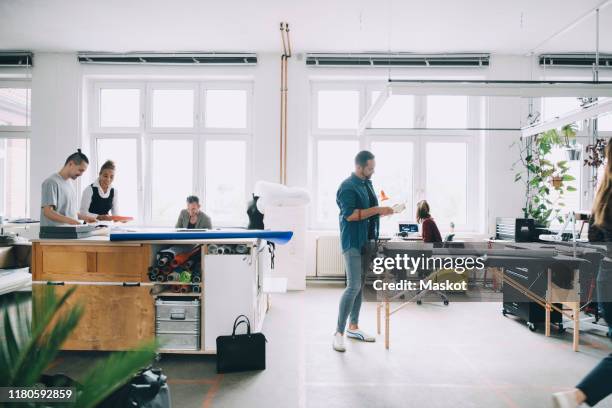 multi-ethnic male and female business professionals working in creative office - agence-de-design photos et images de collection