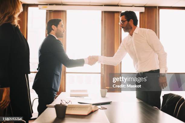 businessman shaking hands with male lawyer after meeting in board room - legal problems stock pictures, royalty-free photos & images