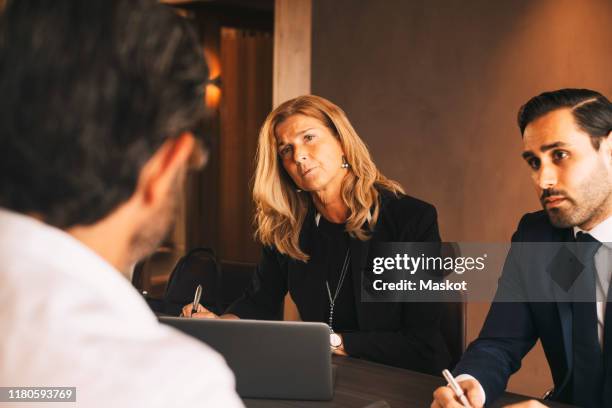 serious legal coworkers listening to mature businessman during meeting at law office - legal problems stock pictures, royalty-free photos & images