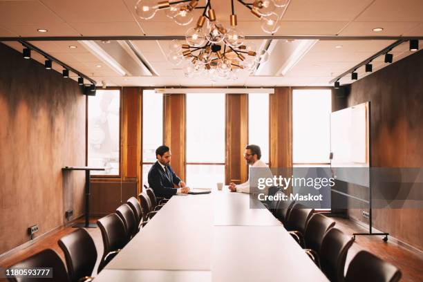 financial advisor discussing with client in board room at law office - legal problems stock pictures, royalty-free photos & images