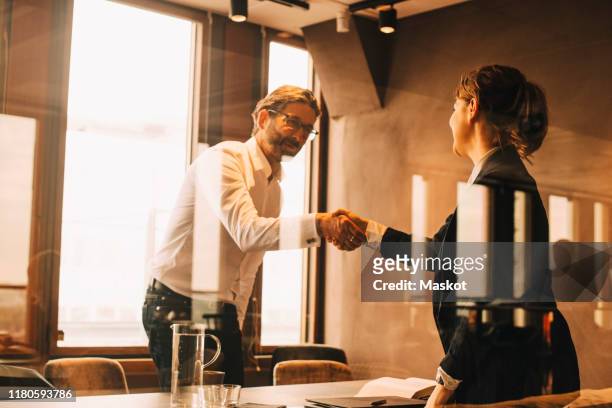 mature customer shaking hands with female lawyer in meeting - legal assistance stock pictures, royalty-free photos & images