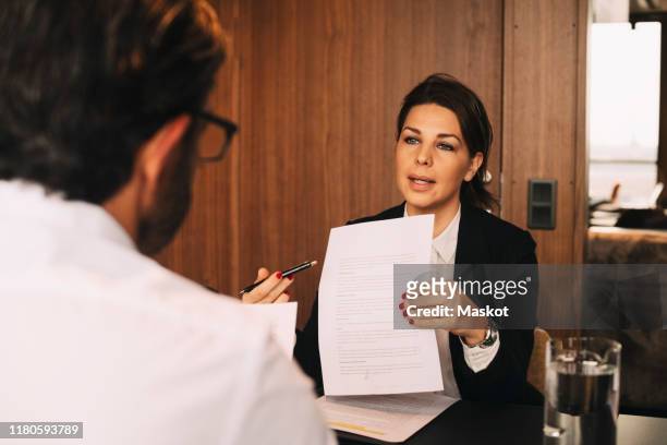 confident lawyer discussing over document with male client at law office - future proof stock pictures, royalty-free photos & images