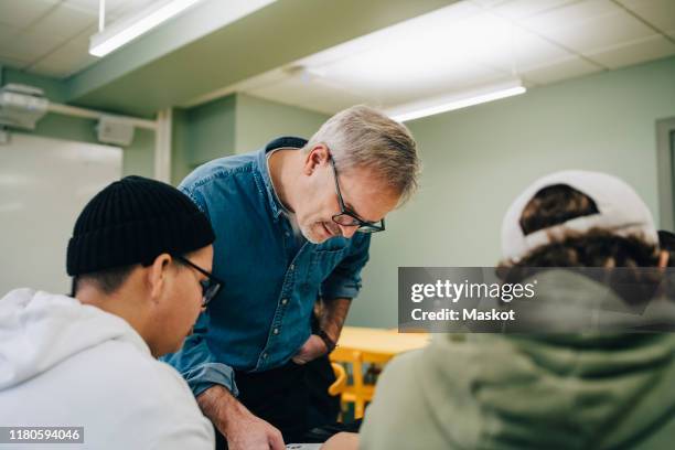 male teacher teaching students in classroom - sweden school stock pictures, royalty-free photos & images