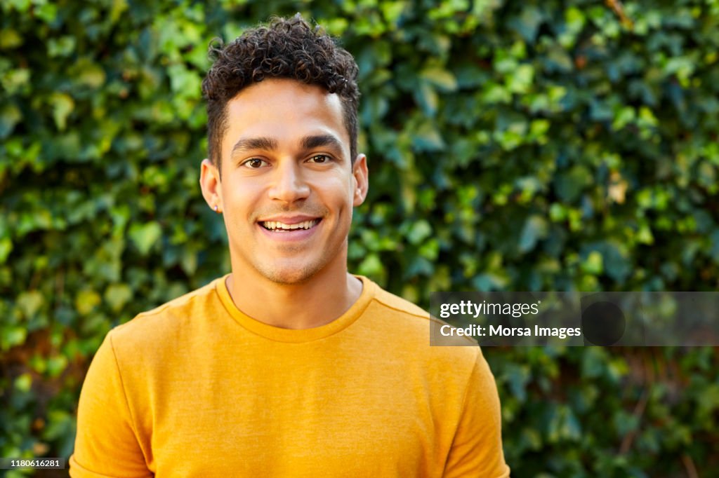 Portrait of young man in yellow t-shirt at backyard