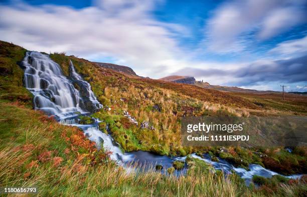 flowing bride's veil waterfall to loch leathan at the storr with old man of storr peak in clouds. - portree imagens e fotografias de stock