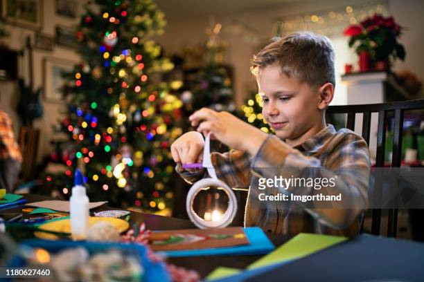 little boy crafting christmas card - child cutting card stock pictures, royalty-free photos & images