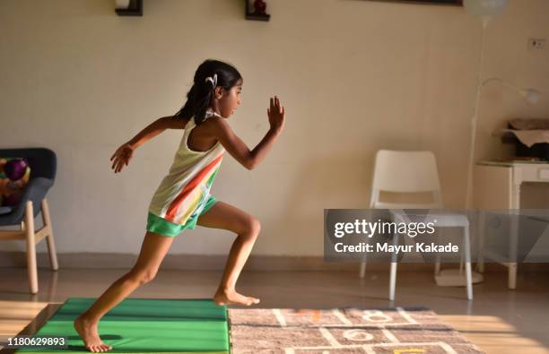 girl displaying her athletics skills at home - häcklöpning löpgren bildbanksfoton och bilder