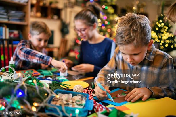 family crafting christmas cards - christmas preparation stock pictures, royalty-free photos & images
