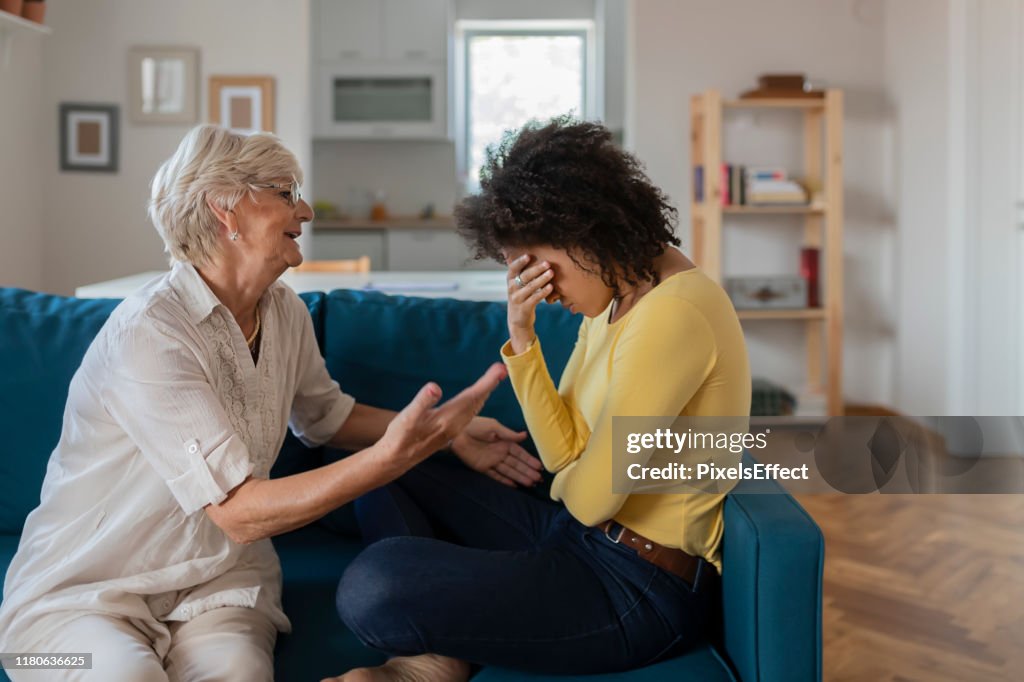 Older Mother Comforting Sad Adult Adopted Mixed Race Grown Daughter