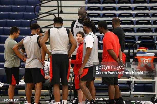 Head coach Darren Erman, center, and members of the Maine Red Claws are dwarfed by 7-foot-5 Tacko Fall during Fall's debut practice on Monday at...