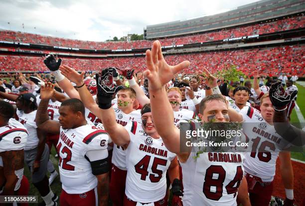 The South Carolina Gamecocks celebrate their 20-17 win over the Georgia Bulldogs in the second overtime at Sanford Stadium on October 12, 2019 in...
