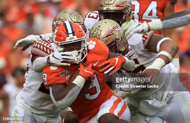 Teammates Cory Durden and Keyshawn Helton of the Florida State Seminoles try to stop Travis Etienne of the Clemson Tigers during their game at...