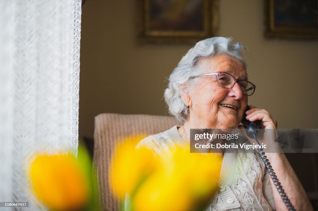 Porträt einer älteren Frau, die mit dem Telefon spricht