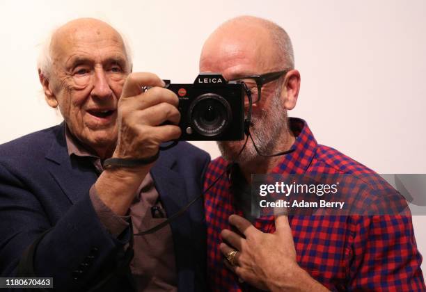 Michael Stipe, former singer of the band R.E.M. , tries out a Leica camera belonging to German photographer Thomas Höpker as they attend a...