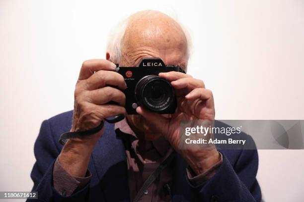 Photographer Thomas Höpker takes a photo with a Leica camera as he attends a presentation of Former R.E.M. Singer Michael Stipe's photo book "Our...