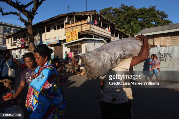 Early morning stall holders and shoppers are seen at the Honiara Central Markets as performers from the 'Solomon Islands Cultural Group' prepare to...