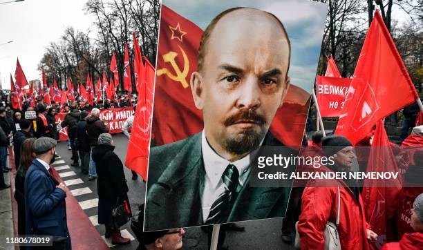 Russian Communist party supporters march in central Moscow with red flags and Lenin's potrait on November 7 marking the 102th anniversary of the...
