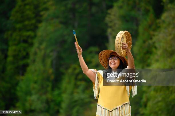 eerste naties vrouw het uitvoeren van een welkom lied - indigenous art stockfoto's en -beelden