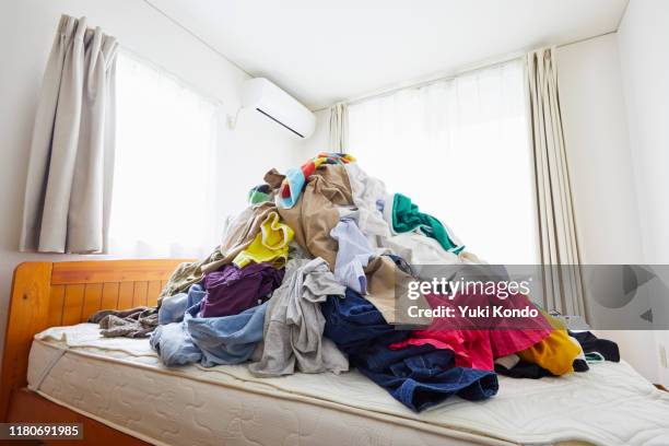 a lot of clothing placed on the bed. - kleidungsstück stock-fotos und bilder